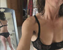 Eine sexy Userin posiert vor einem Spiegel